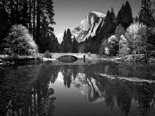 Photo du Yosemite National Park, avec un pont et le reflet d'une montagne dans l'eau.